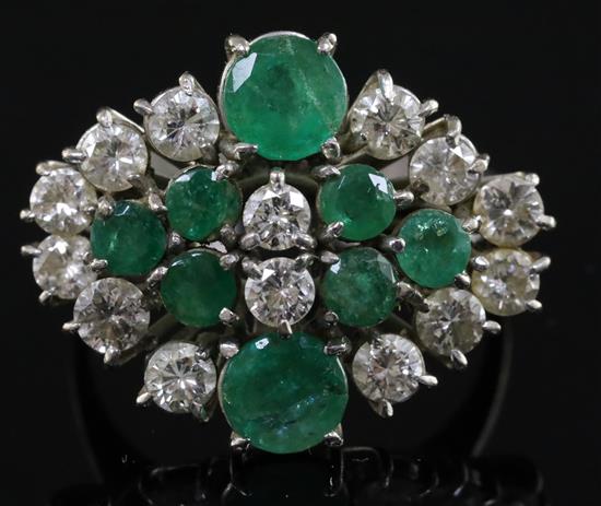 An 18ct white gold, diamond and emerald cluster dress ring, size P/Q.